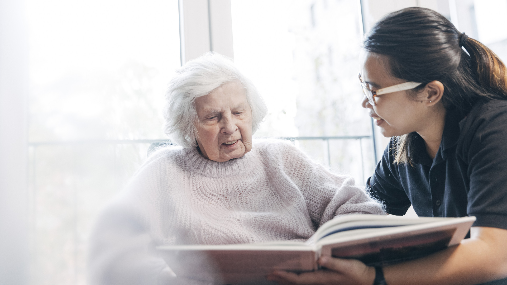 Pflegekraft liest Patientin vor